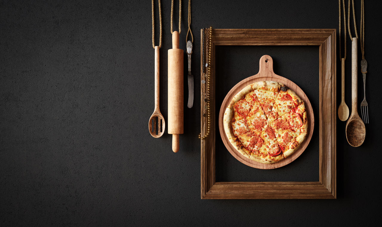 Hot pizza slice with kitchen tools and frame concept close up photo