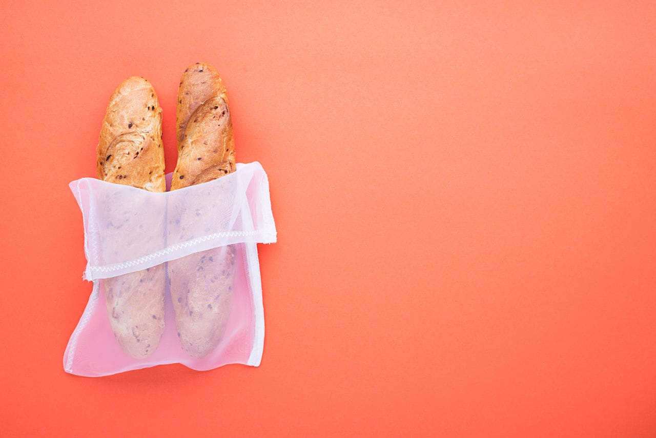 Eco bag package. Zero waste house shopping kitchen products. The main modern concept is no plastic. On a pastel colored background bread, baguettes.  Copy space