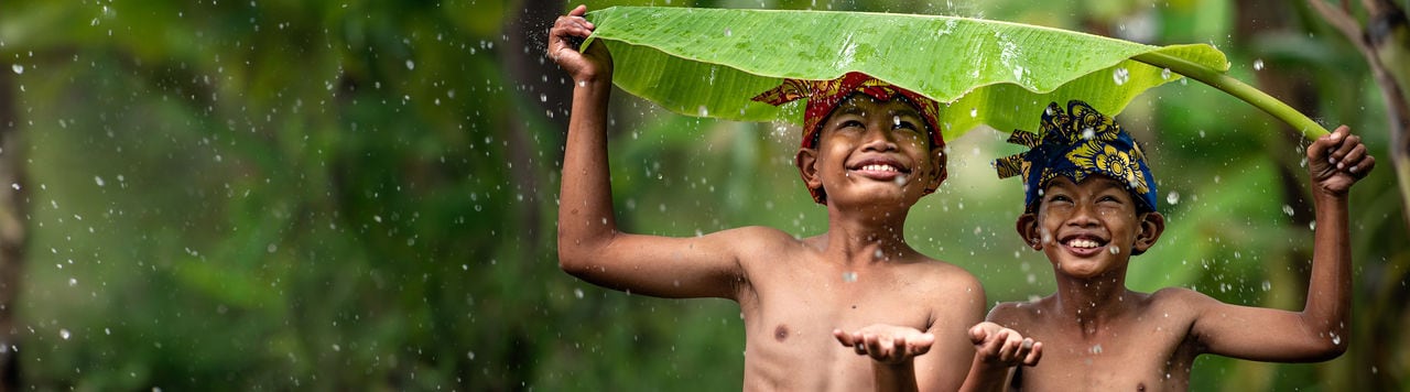 Indonesia children farmer playing rain. Asian kid smile. Indonesian concept.