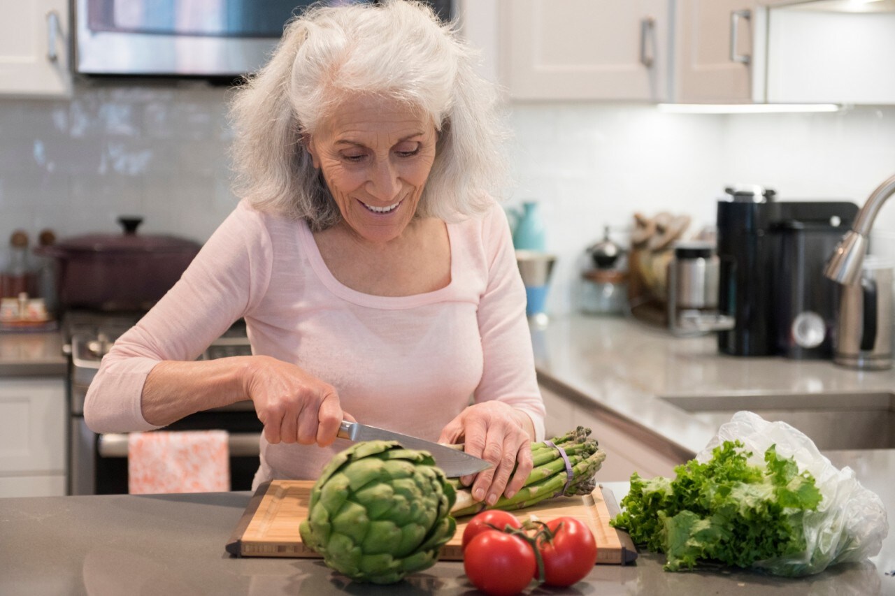 Older woman chopping asparagus