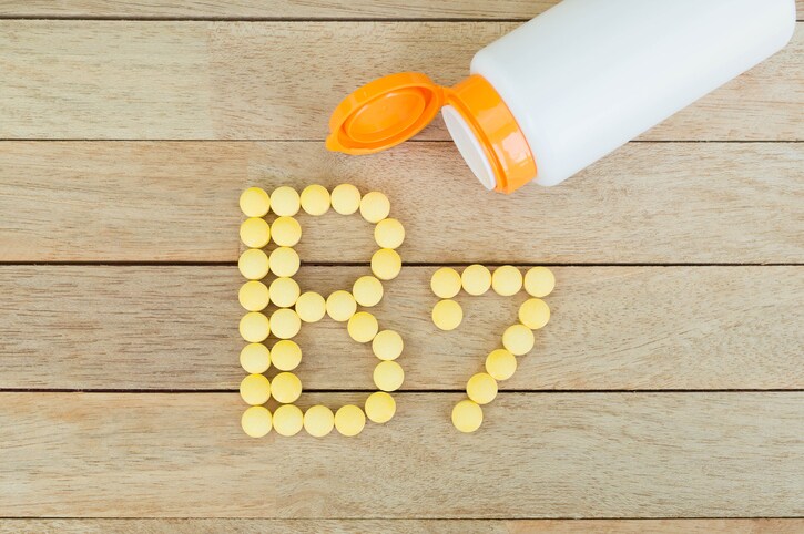 Yellow pills forming shape to B7 alphabet on wood background