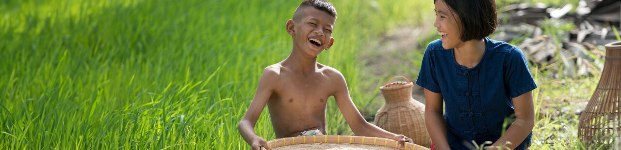 Asia farmer child happiness and siting in farmland.