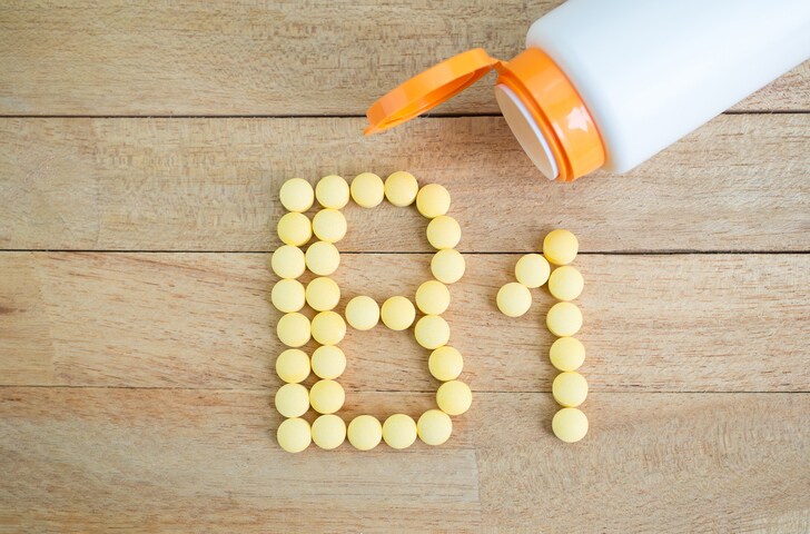Yellow pills forming shape to B1 alphabet on wood background