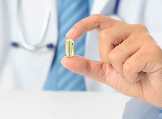 Doctor showing yellow pill.
