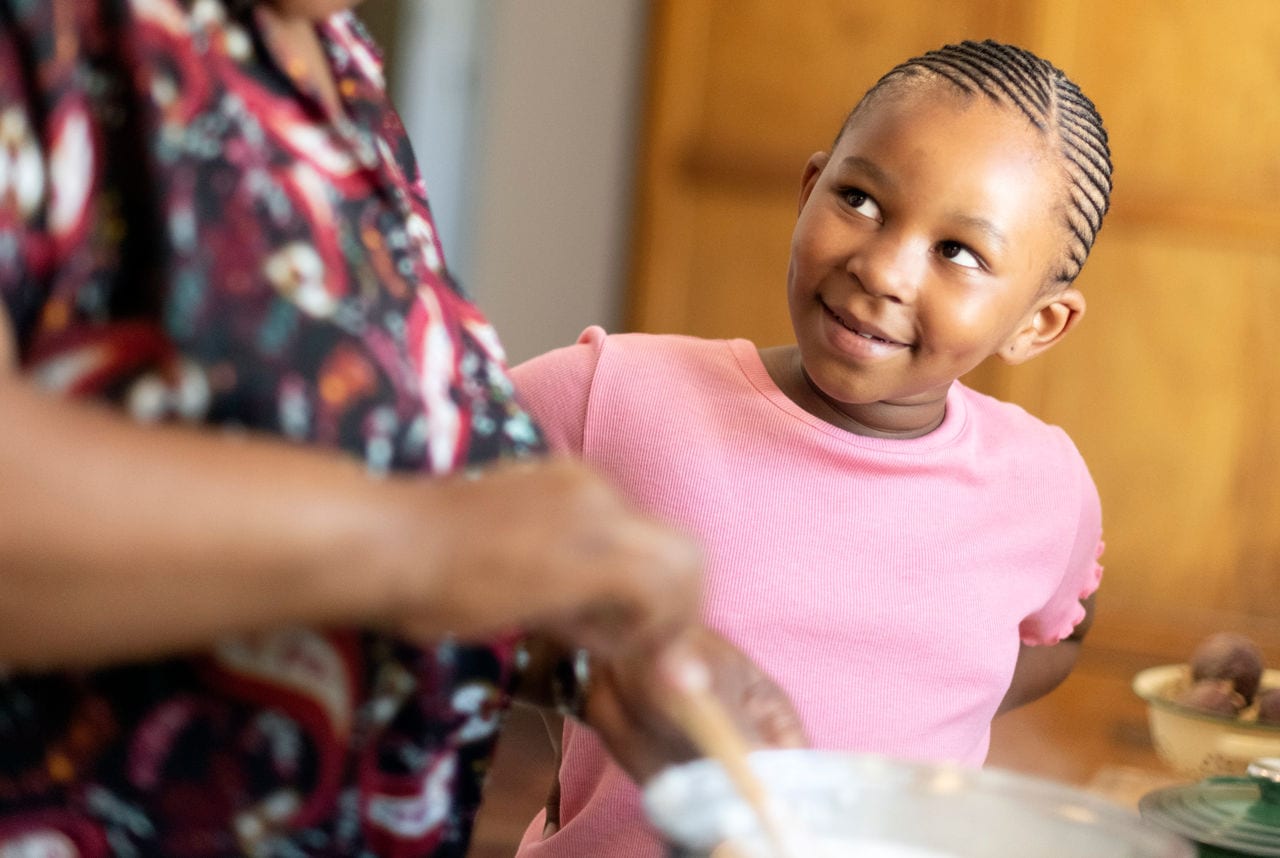 Little girl listens to grandmother while she cooks