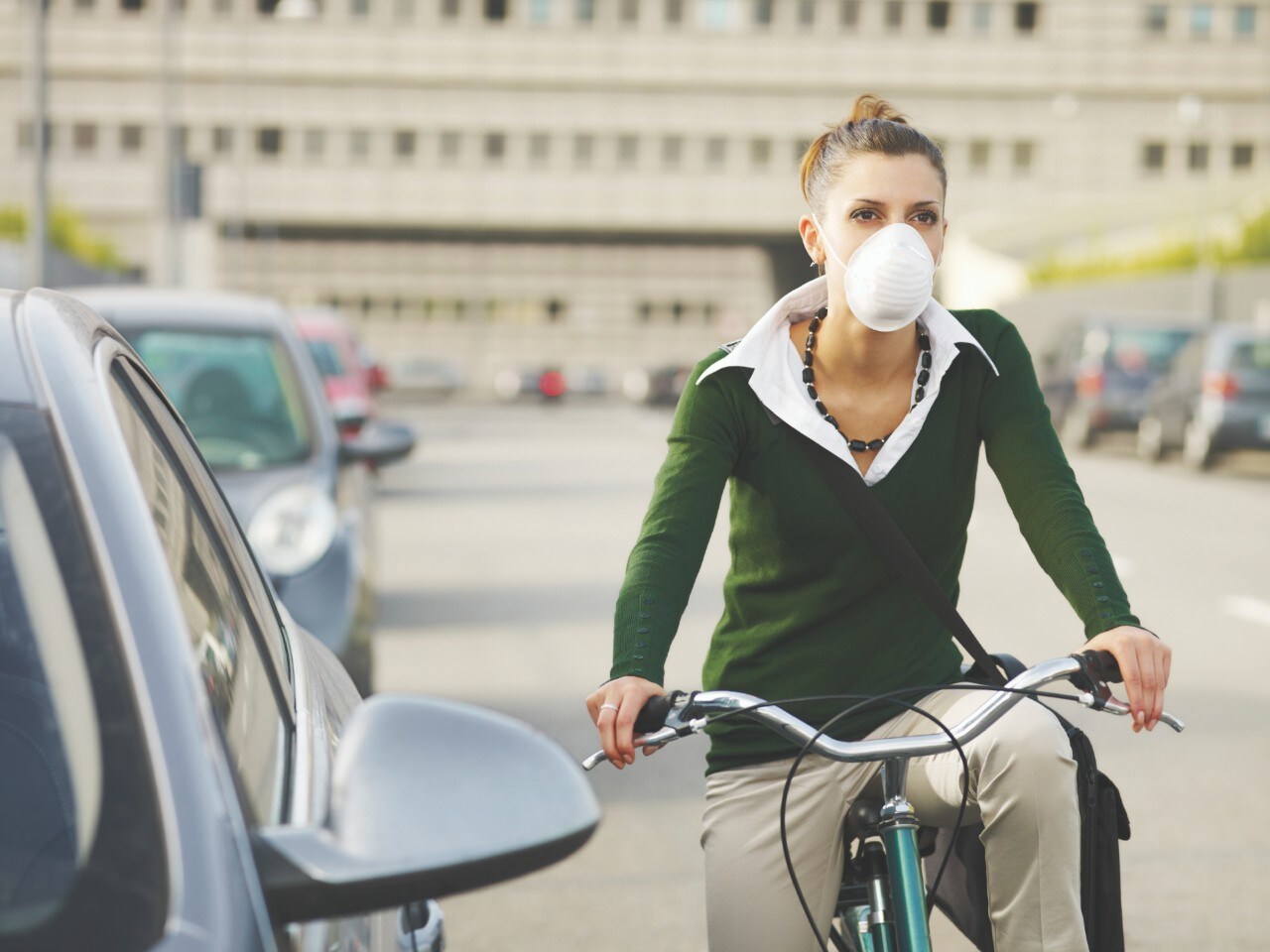 woman with dust mask commuting on bicycle