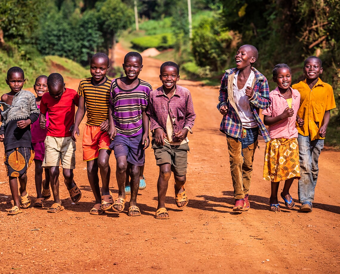 Group of colorful dressed, happy African children running in Central Kenya, East Africa