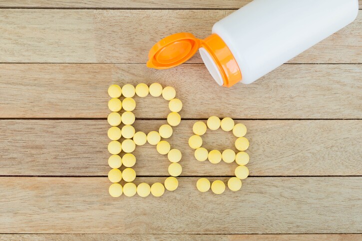 Yellow pills forming shape to B9 alphabet on wood background