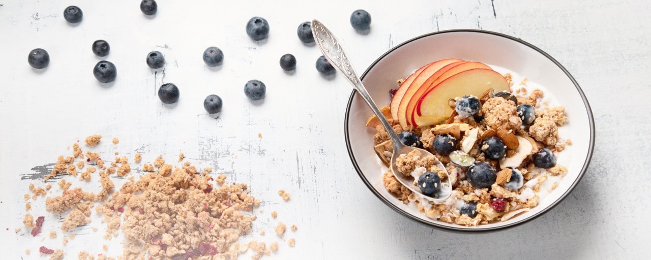 Bowl of granola with yogurt and fresh fruits for healthy breakfast.