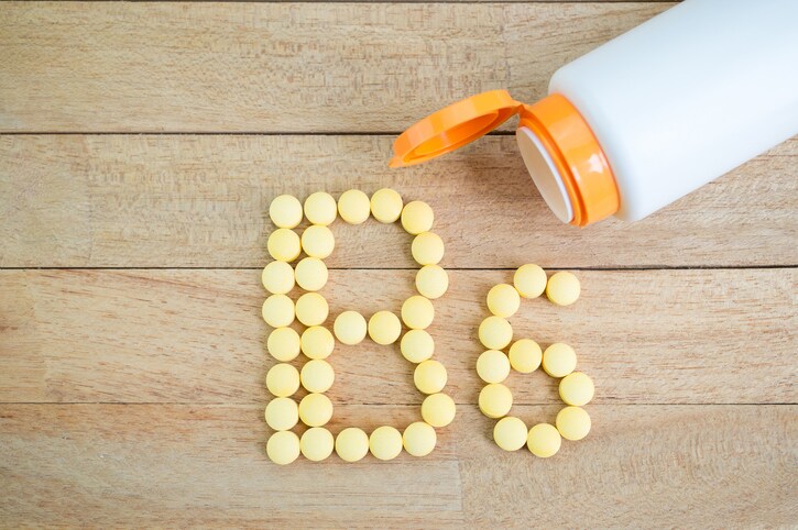 Yellow pills forming shape to B6 alphabet on wood background