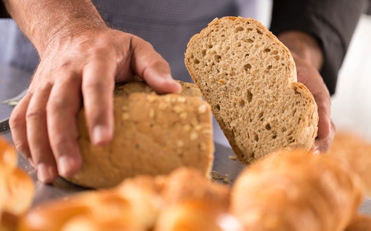 Foto de dos manos sosteniendo dos trozos de pan.