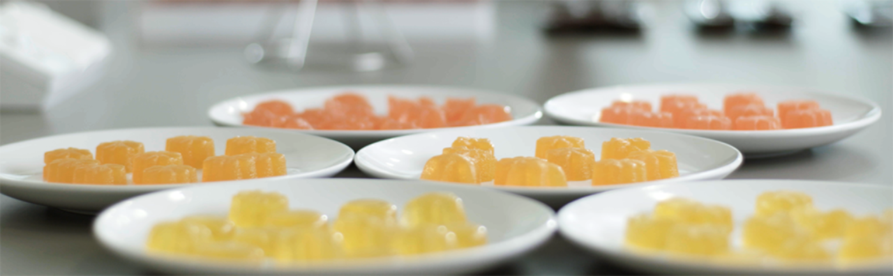 Foto de seis platos en una superficie. En el interior de cada uno de ellos, hay porciones de vitaminas con textura gelatinosa.