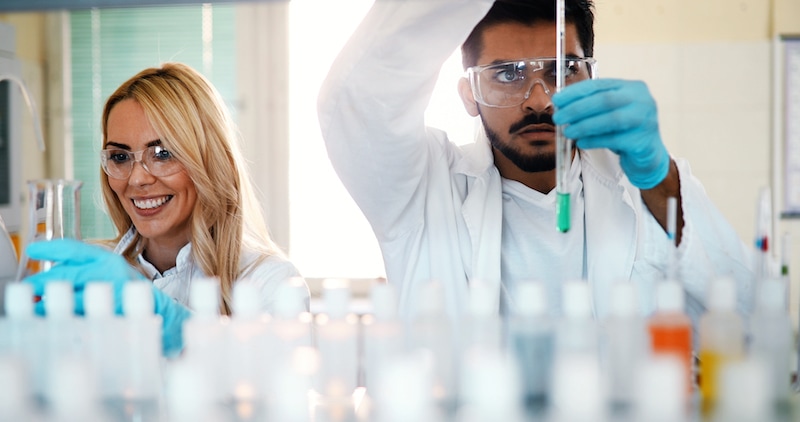 Foto de dois cientistas - um homem e uma mulher - em um laboratório.