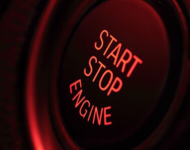 Foto de um botão de ignição com os textos “Start. Stop. Engine.”