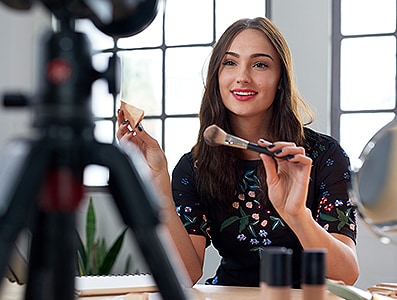 Pretty beauty vlogger recording make-up tutorial promoting product, social media marketing