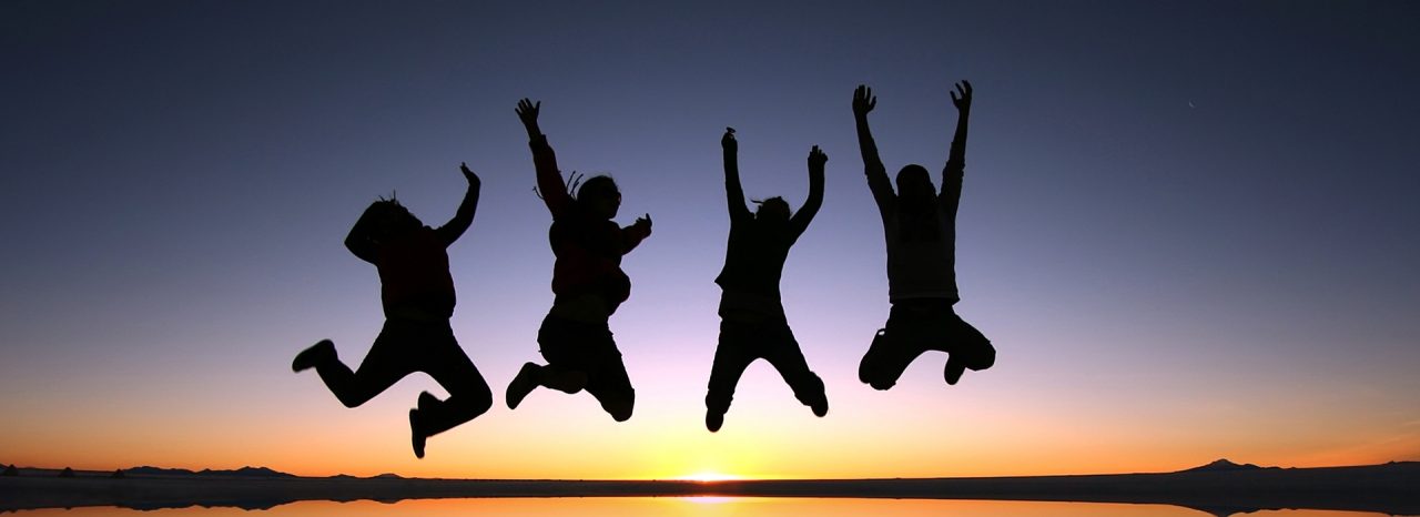A group of happy young friends jumping in Solar de Uyuni, Bolivia